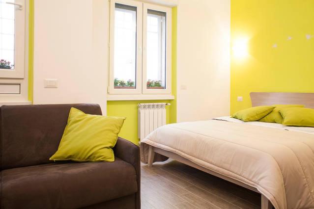1 dormitorio con 1 cama, 1 sofá y 2 ventanas en The Green Corner, en Roma