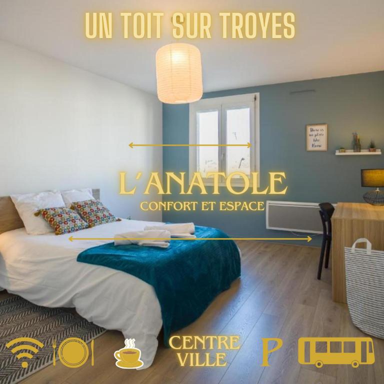 une chambre avec un lit avec un mur bleu dans l'établissement L'Anatole Wifi Parking, à Troyes