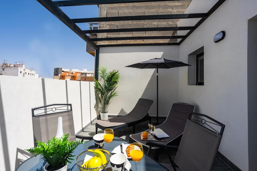 a patio with a table and chairs and an umbrella at Eslanzarote Aptos Mozaga, parking,superwifi in Arrecife