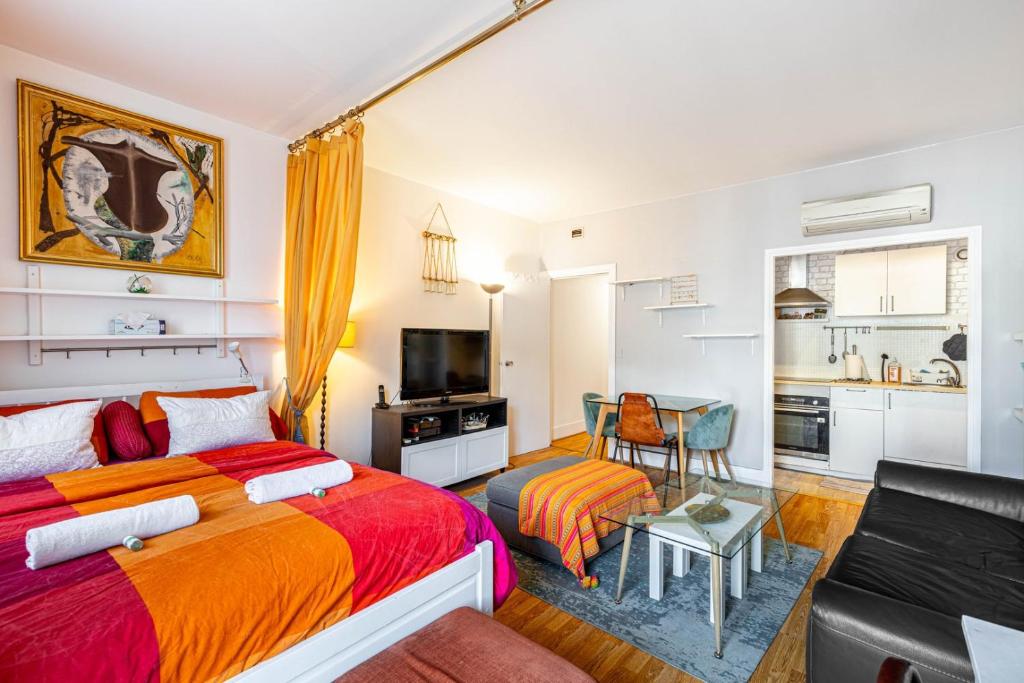 une chambre avec un grand lit et un salon dans l'établissement GuestReady - Cosy studio near Arc de Triomphe, à Paris