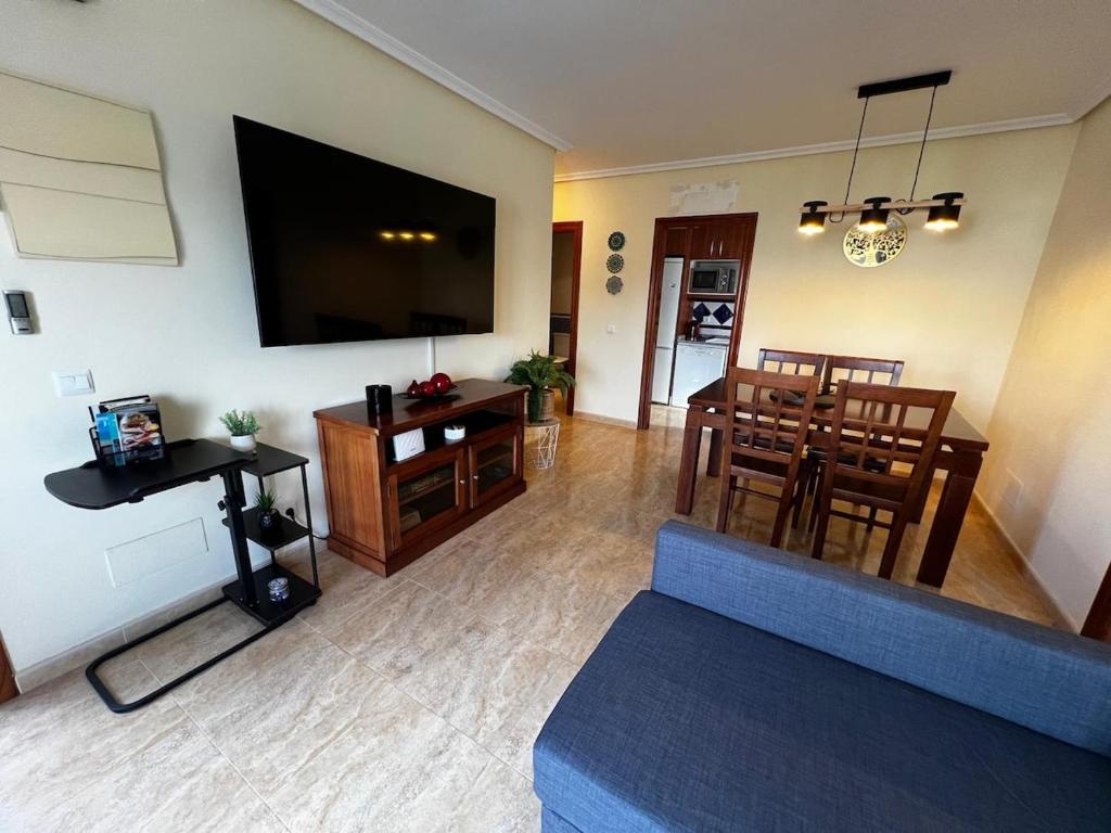 a living room with a television and a dining room at Spectacular Flat Vera Playa in Playas de Vera