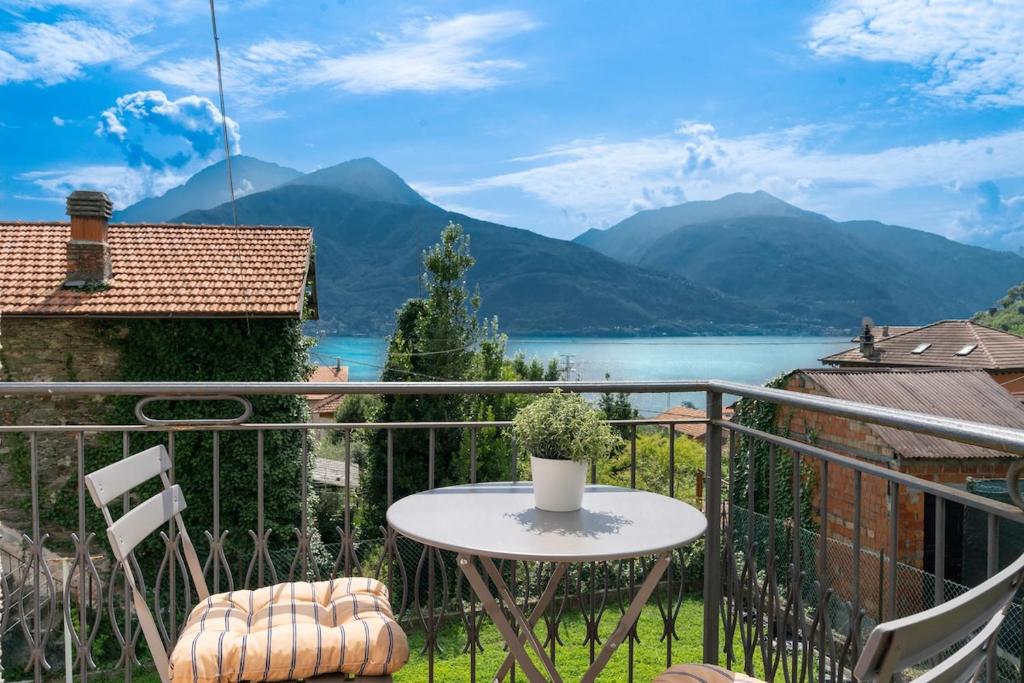 balcón con mesa, sillas y vistas al lago en COMO LAKE VIEW Jasmin's Family House, en Musso