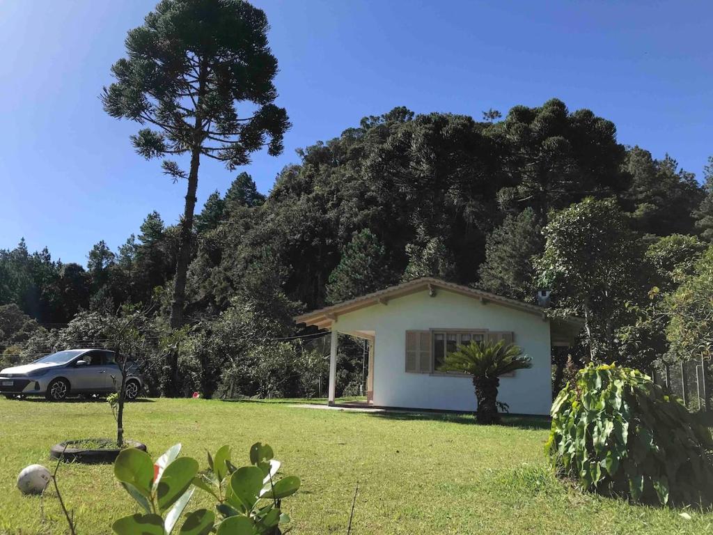 ein kleines weißes Haus vor einem Berg in der Unterkunft Casa de Campo, Pet friendly em Campo Alegre-SC in Campo Alegre