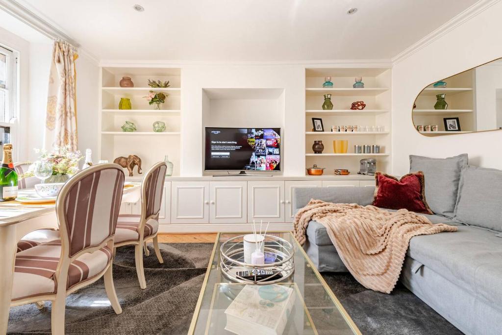 a living room with a couch and a table at Secluded Modern Private Apartment by Buckingham Palace in London