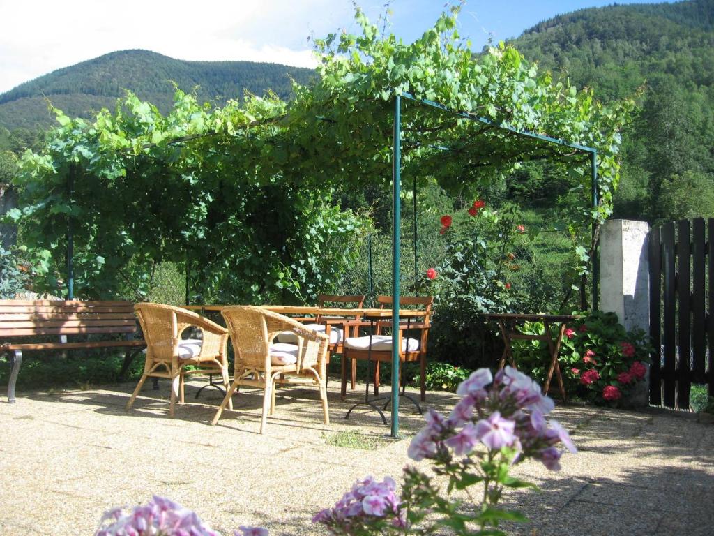 d'une terrasse avec une table, des chaises et un banc. dans l'établissement maison familiale en montagne près d'Ax les thermes, à Caussou