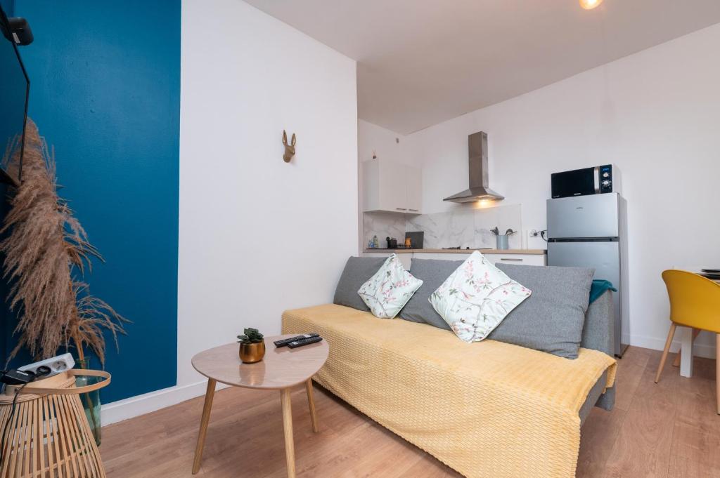 un salon avec un canapé et une table dans l'établissement Lorient T2 , Hypercentre , Gare, à Lorient