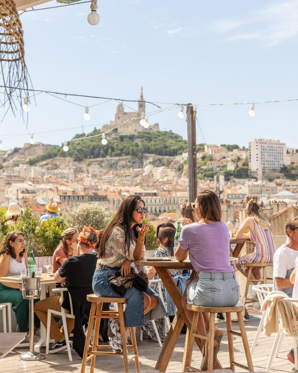 un groupe de personnes assises à une table dans un restaurant dans l'établissement The Babel Community Hôtel - Vieux Port, à Marseille