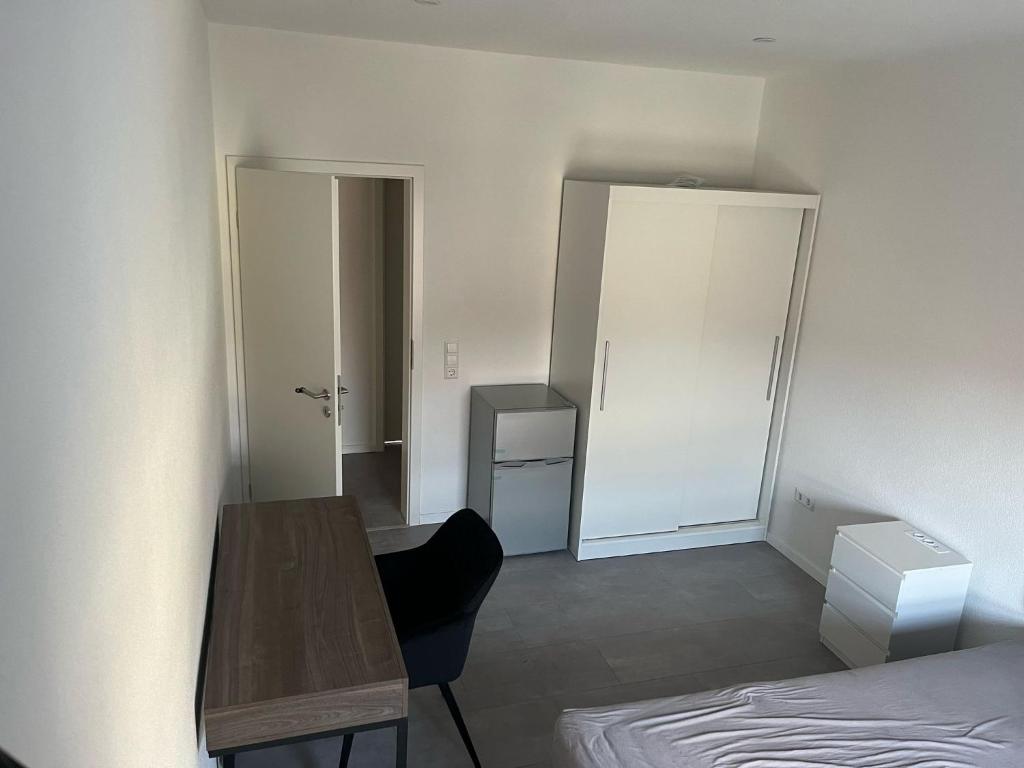 a room with a bed and a table and a door at Bifi 55 in Aalen