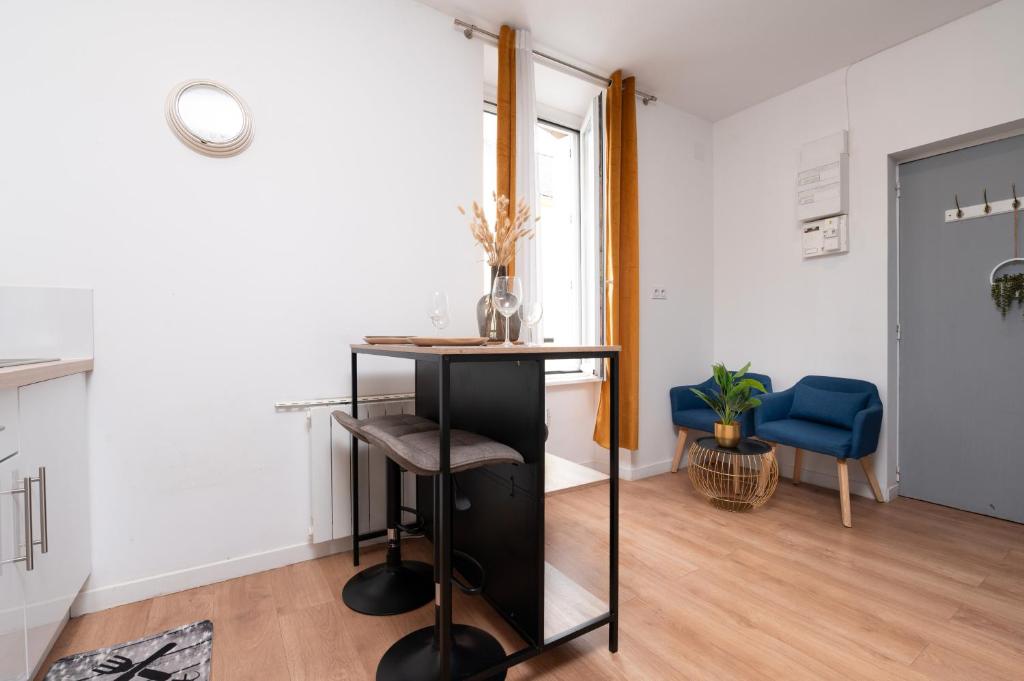 - un salon avec une table et une chaise bleue dans l'établissement Studio - Centre - Gare - Fibre, à Lorient