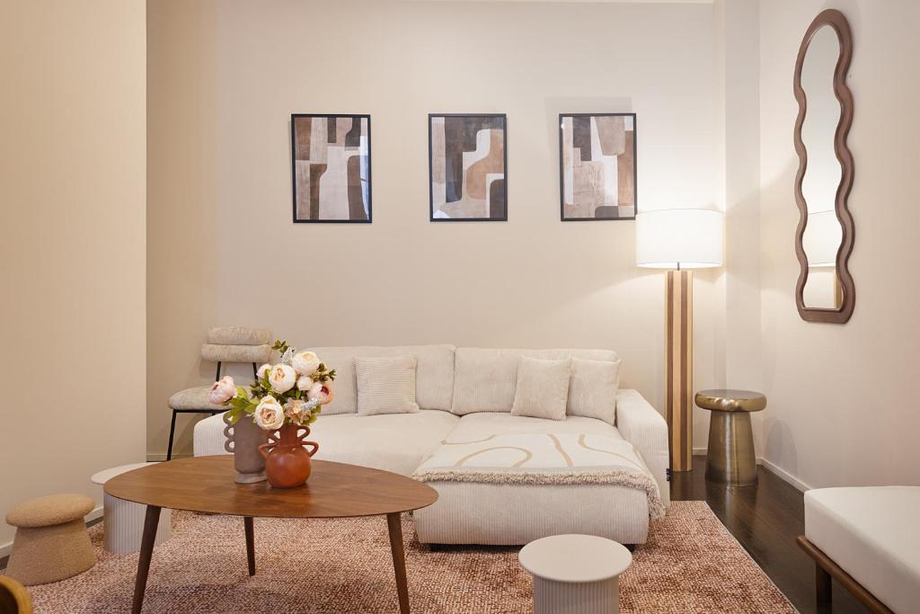 un salon avec un canapé blanc et une table dans l'établissement Magnifique Appartement au Cœur du Marais, à Paris