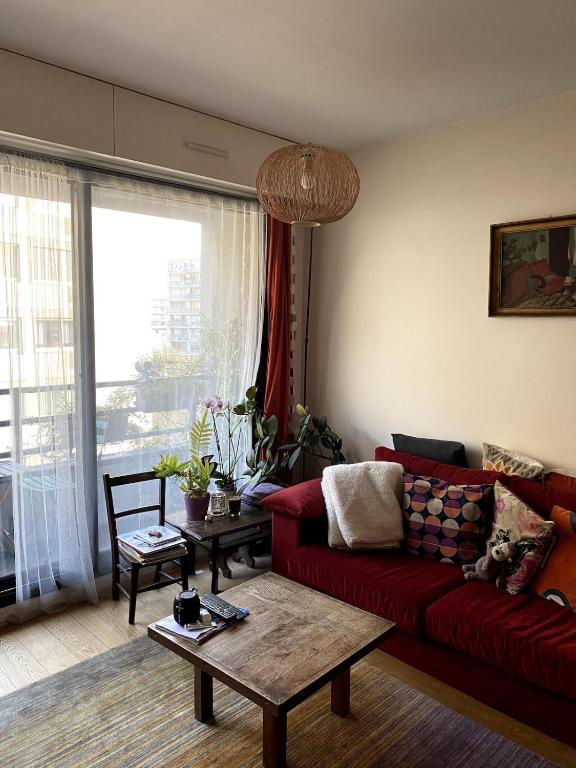 un salon avec un canapé rouge et une table dans l'établissement Couronnes 2 bis - CI - Apartment 55m2 Paris Couronnes with balcony, à Paris