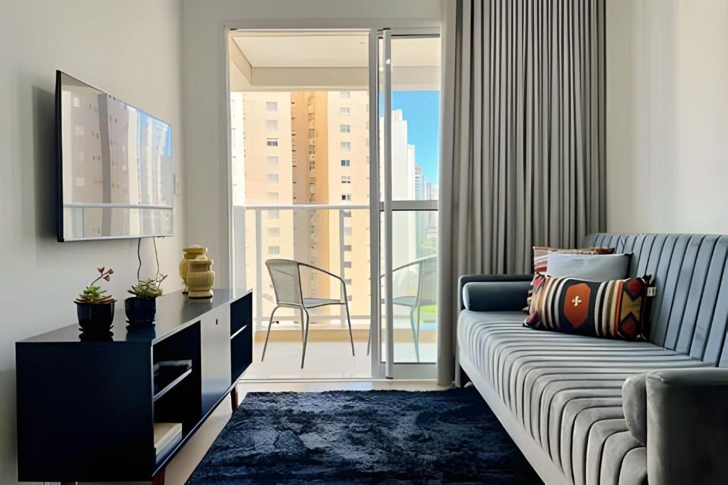 a living room with a couch and a large window at Moderno apto - vista maravilhosa in Londrina