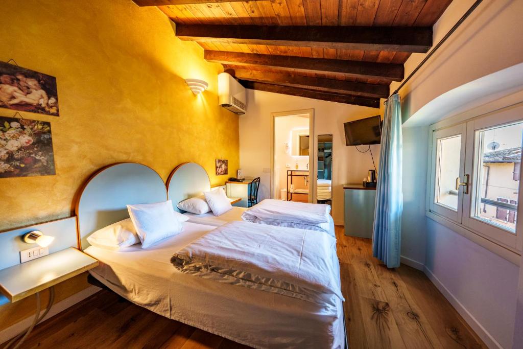 una camera da letto con un letto grande e una finestra di Hotel San Filis a San Felice del Benaco