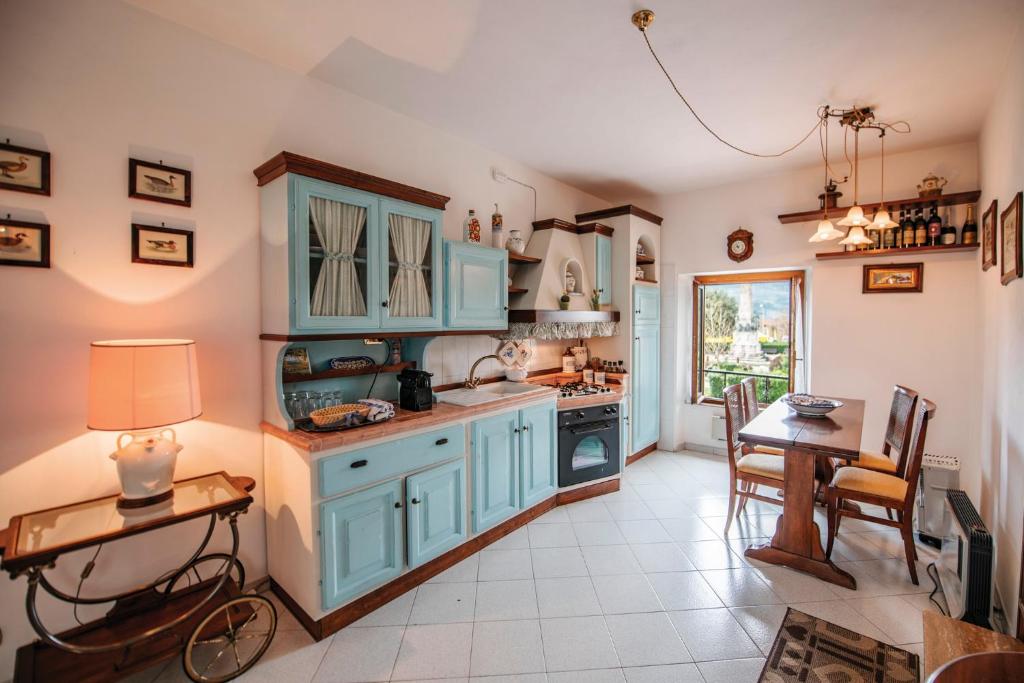 a kitchen with blue cabinets and a table at Bellavista free parking city center in San Gimignano