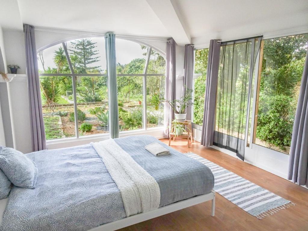 une chambre avec un lit et de grandes fenêtres dans l'établissement Quinta de Lagos, à Lagos