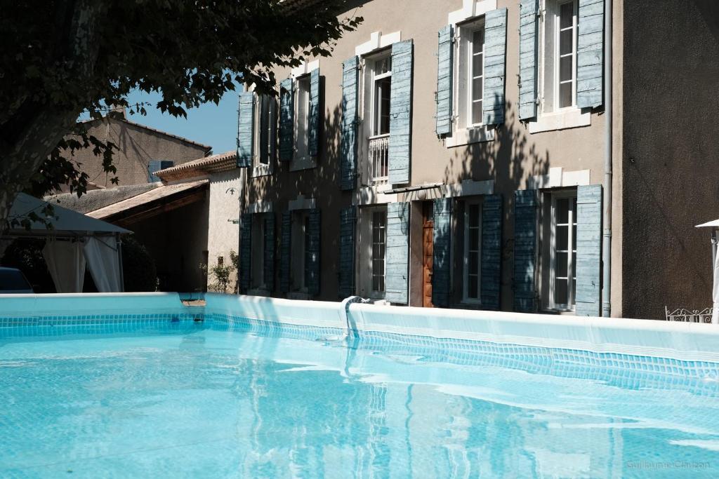 une grande piscine devant un immeuble dans l'établissement La maison du bonheur, à Pélissanne