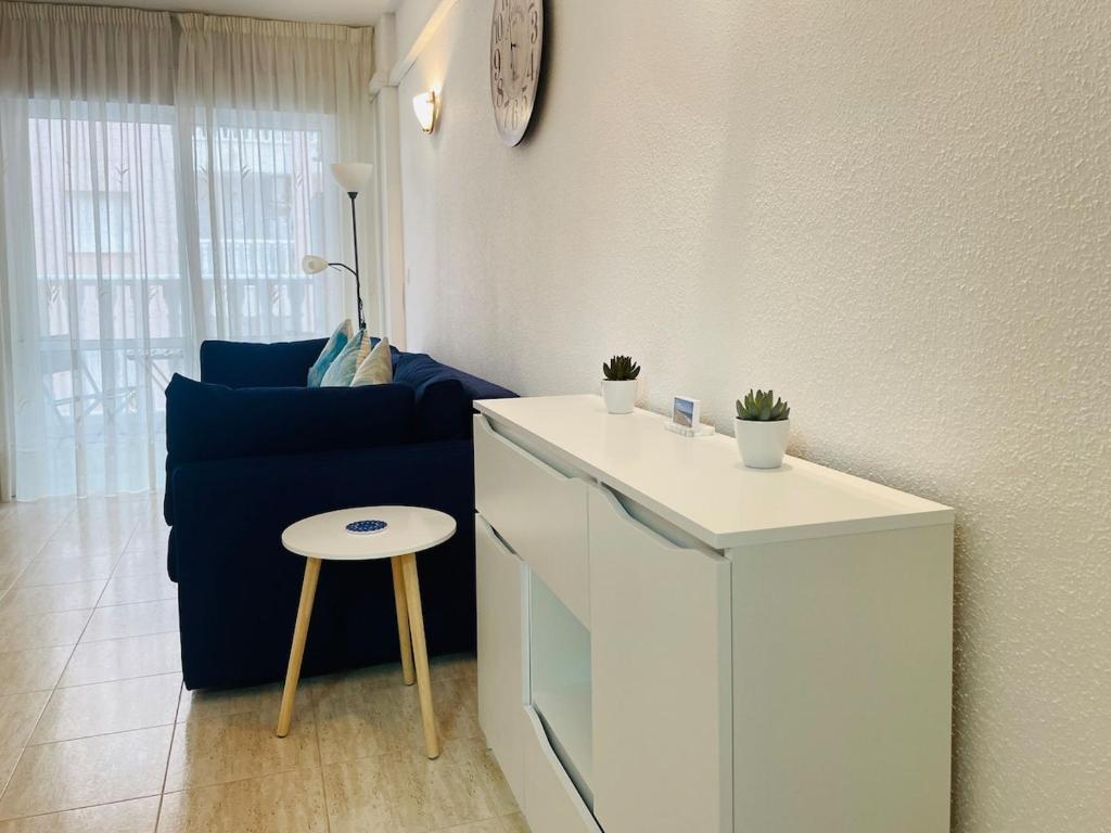 un soggiorno con divano blu, tavolo e sgabello. di Comfortable apartment with 2 bedrooms and Pool a Torrevieja