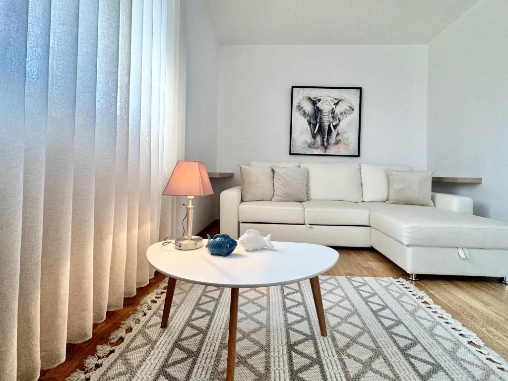 a living room with a white couch and a table at Apartments Terra Solaris in Medulin