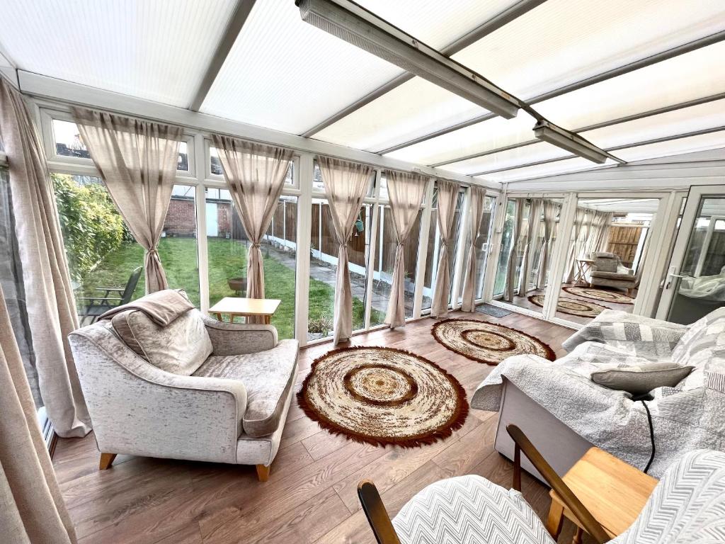 a large living room with windows and chairs at Surrey Street Retreat in Wallasey
