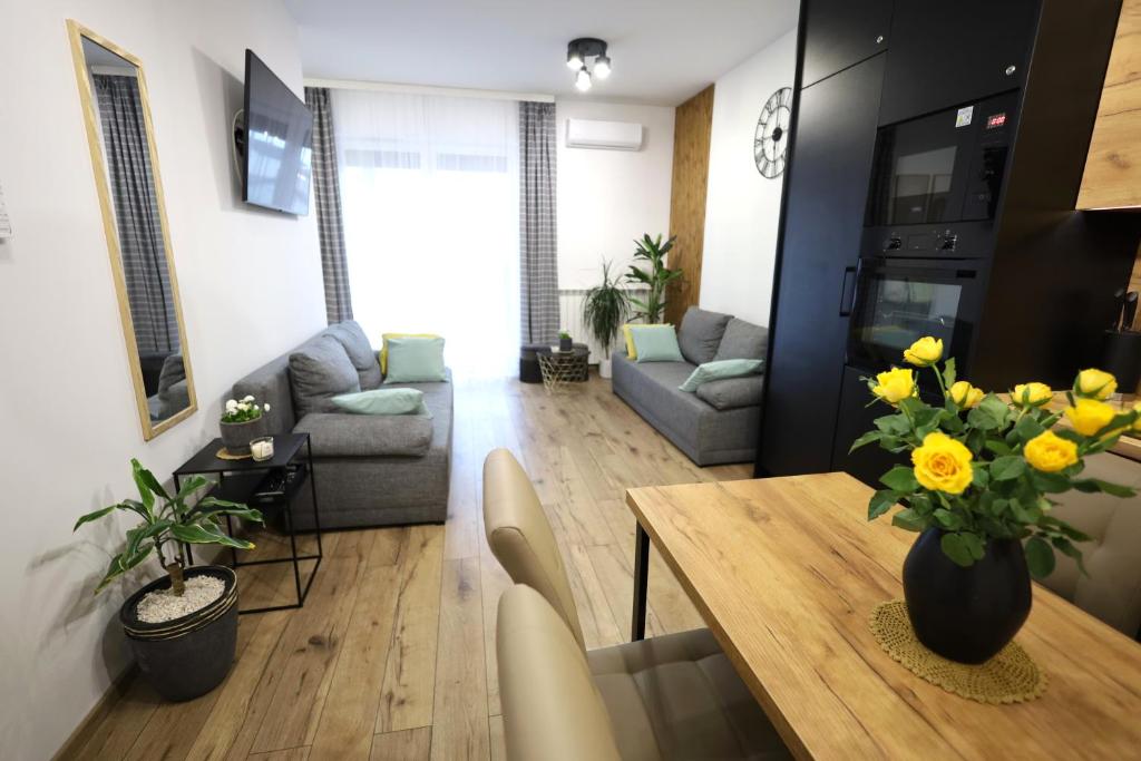 sala de estar con mesa de comedor con flores amarillas en Apartament LUX, en Zator