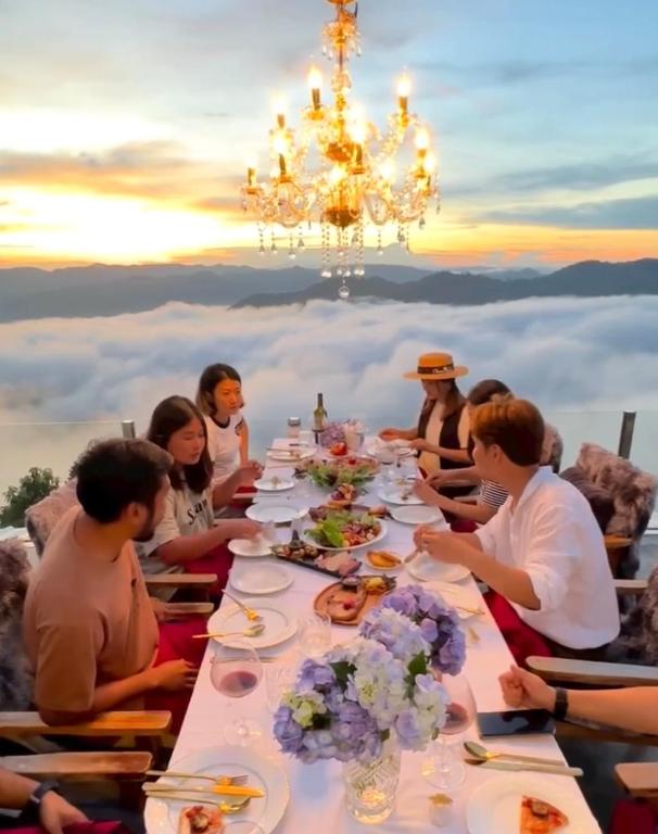 a group of people sitting at a table with a chandelier at Cheevavavee Doichang Chiangrai in Ban San Pu Loei