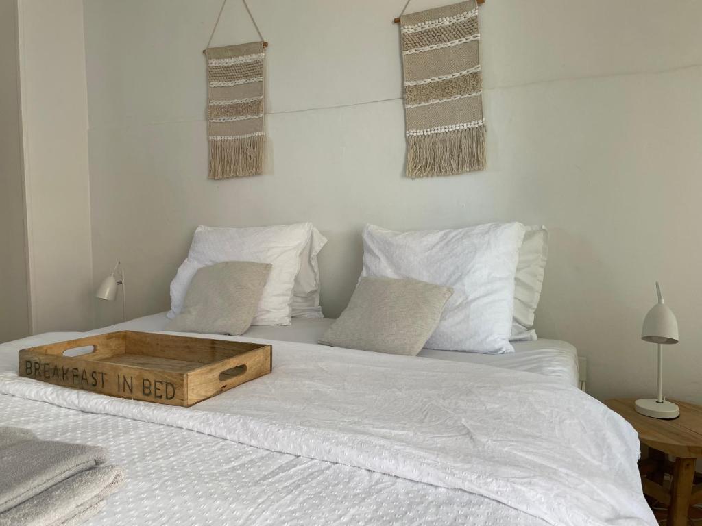 a bed with a wooden tray on top of it at Studio Den Burg in Den Burg