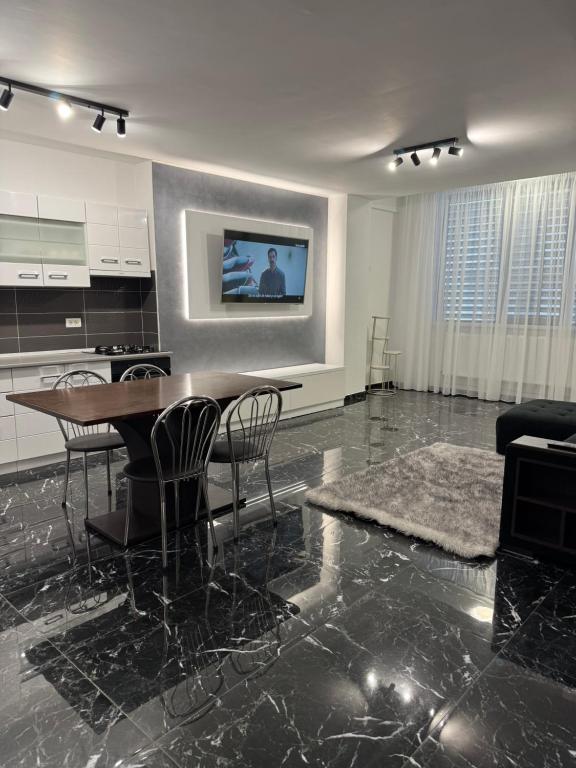 a living room with a table and a kitchen at Black Sea Apartment in Constanţa
