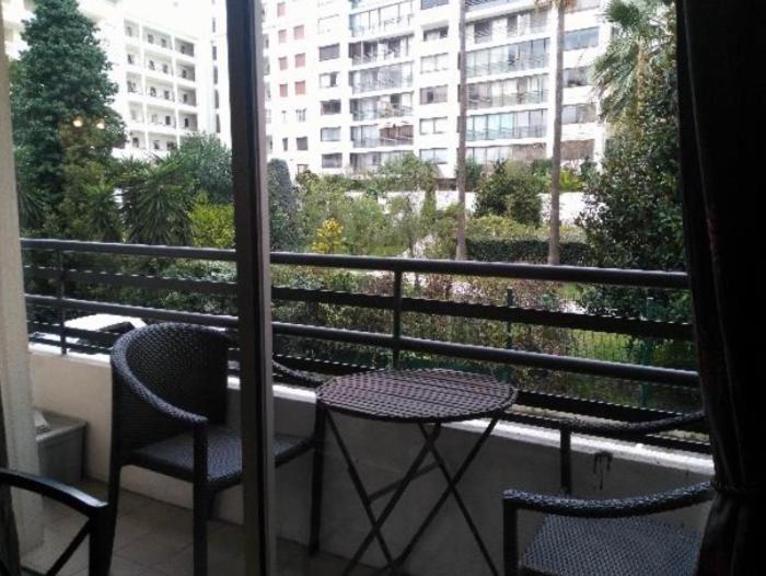 un balcon avec une table et deux chaises et une fenêtre dans l'établissement Centre Cannes Rouaze, à Cannes