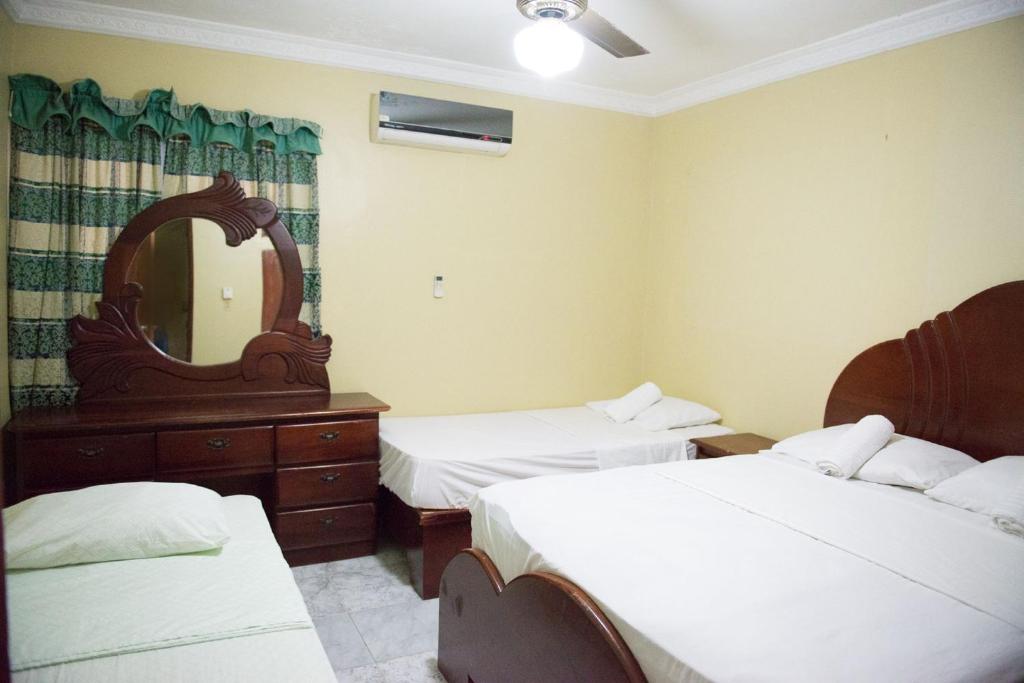 a hotel room with two beds and a mirror at 2 Bedroom Apartment in Corales del Sur - Parque del Este - Las Americas Airport in La Viva