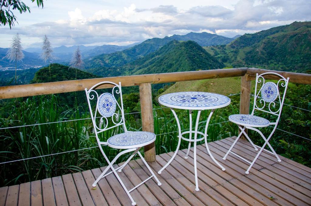 two chairs and a table on a deck with mountains at Ecobindu-Domo in Albán