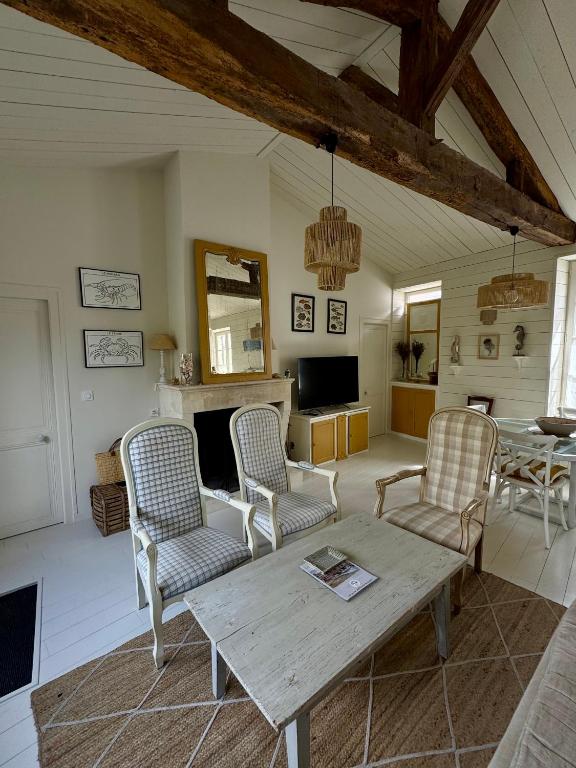 un salon avec une table et des chaises en bois dans l'établissement Maison de charme 3 chambres Ile de Ré, la Couarde, à La Couarde-sur-Mer