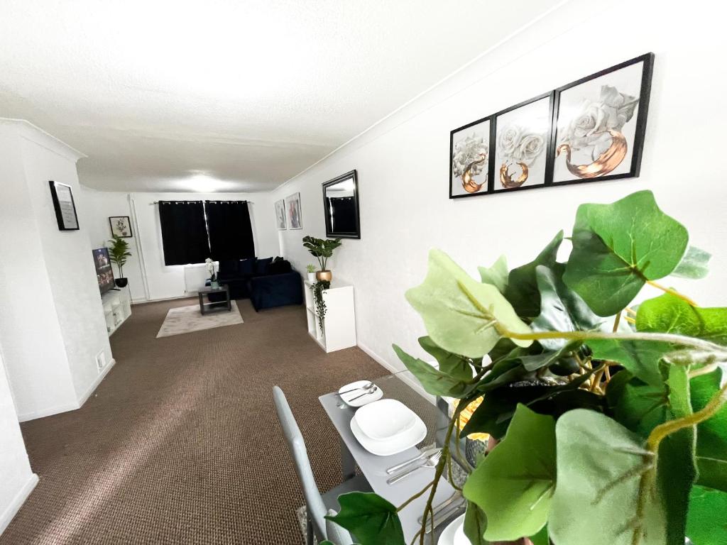 a living room with a table and some plants at 3 Bedroom House, WiFi & Free Parking in Chatham