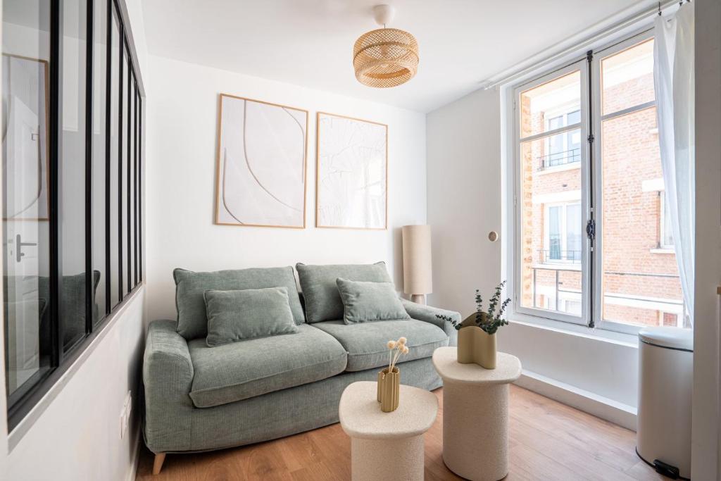 Una sala de estar con un sofá y algunas ventanas. en Cosy 1BR, Newly Renovated - Clichy | By Airnest, en Clichy