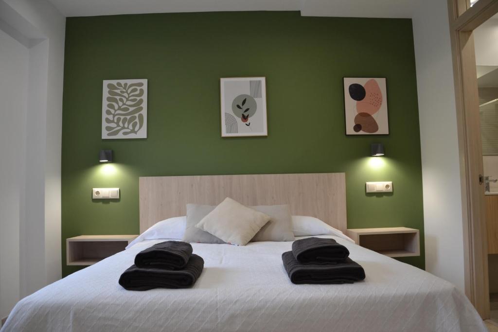 a bedroom with a large bed with two towels on it at Avío Apartamentos in Santiago de Compostela