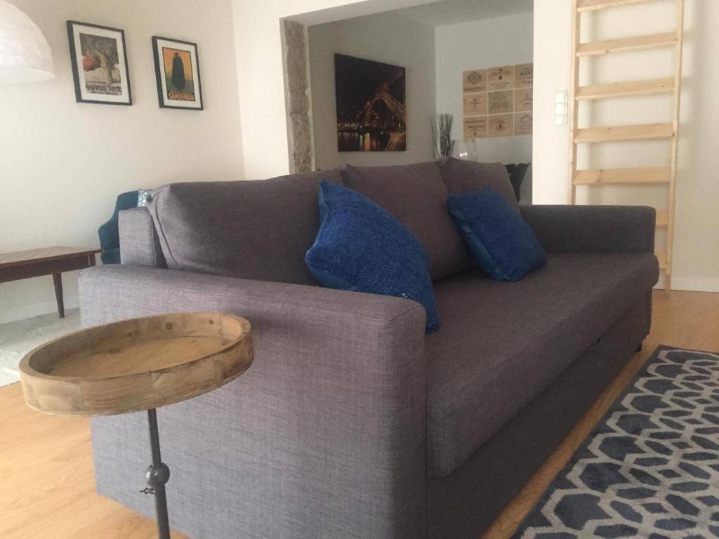 sala de estar con sofá gris y almohadas azules en Porto Wine & Charm By Living Well, en Vila Nova de Gaia