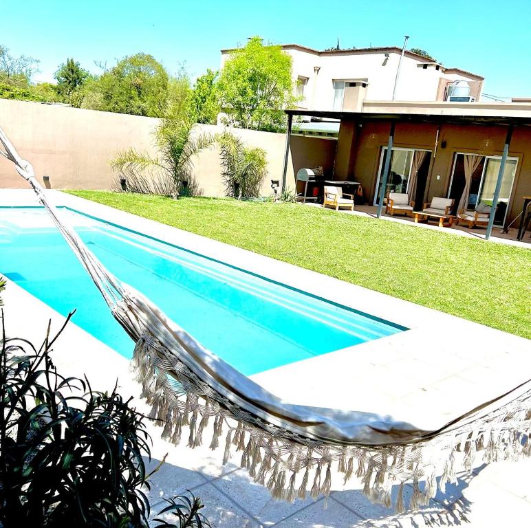 a swimming pool in front of a house at La Merced Areco in San Antonio de Areco