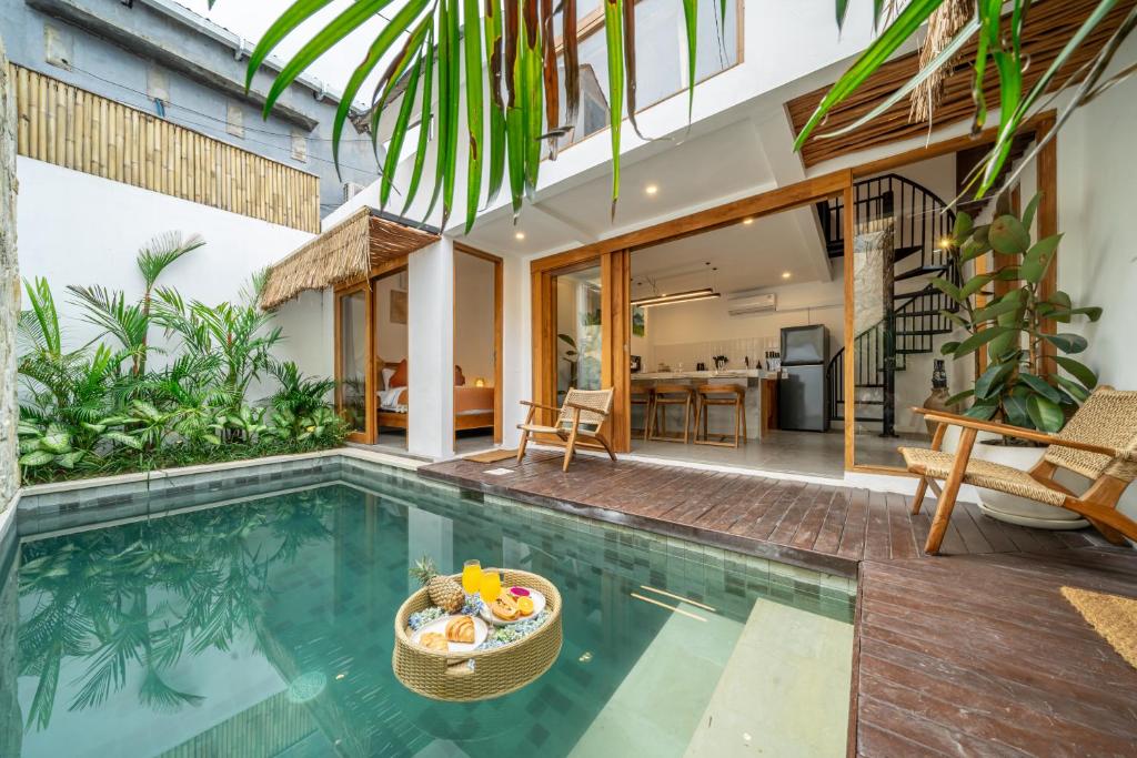 an indoor pool with a table and chairs and a house at Exquisite 3-Bedroom Villa in Seminyak with Private Rooftop Oasis in Kerobokan