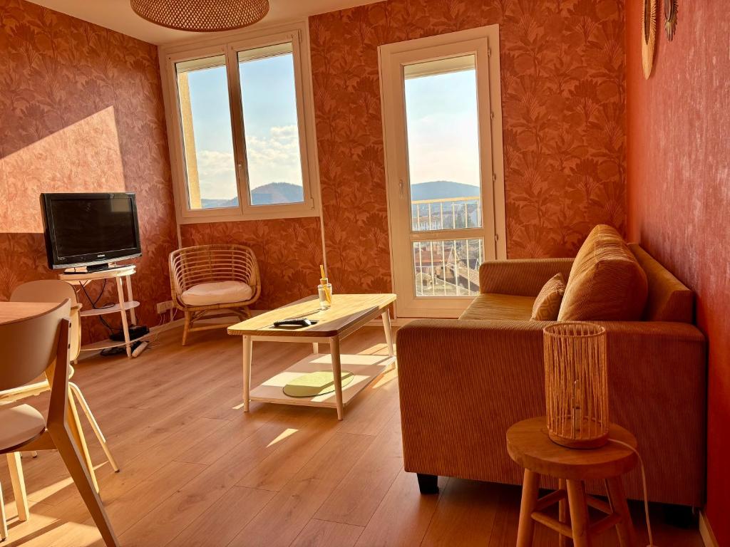 un salon avec un canapé et une télévision dans l'établissement Appartement 3 chambres avec vue et parking, à Besançon