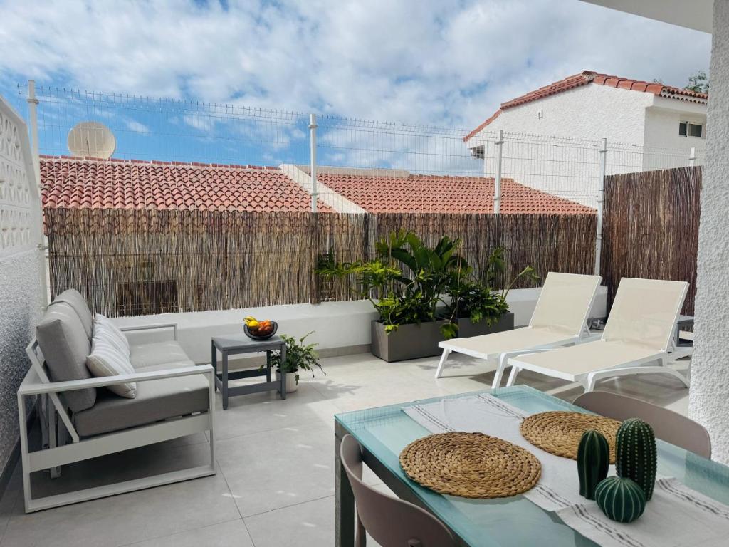 un patio con tavolo e sedie su un balcone di Endless Summer Suite - swimming pool - AC ad Adeje