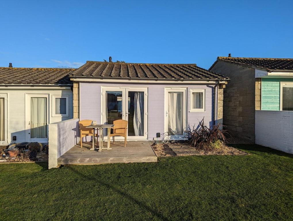 a house with a patio with a table and chairs at Saltbox B4 holiday cottage in Freshwater