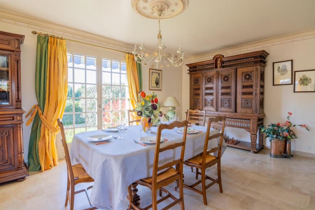 Saint-Clément-des-LevéesにあるLa belle échappéeのダイニングルーム(椅子とテーブル、シャンデリア付)