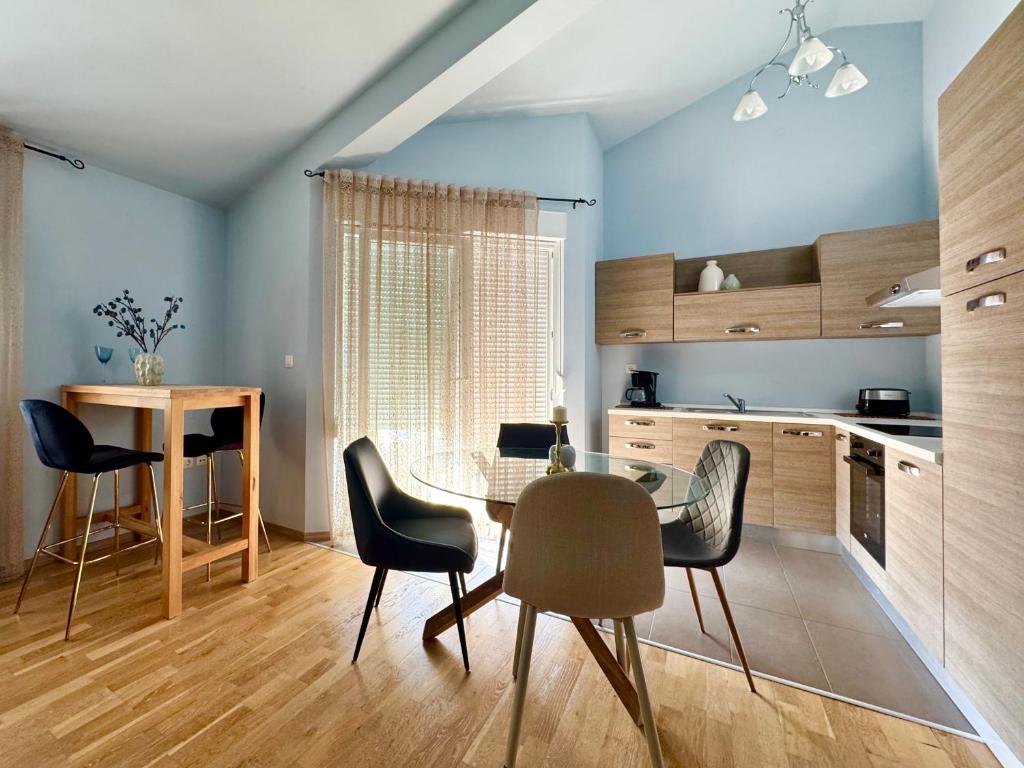 a kitchen with a glass table and chairs in a room at Apartments Terra Solaris in Medulin