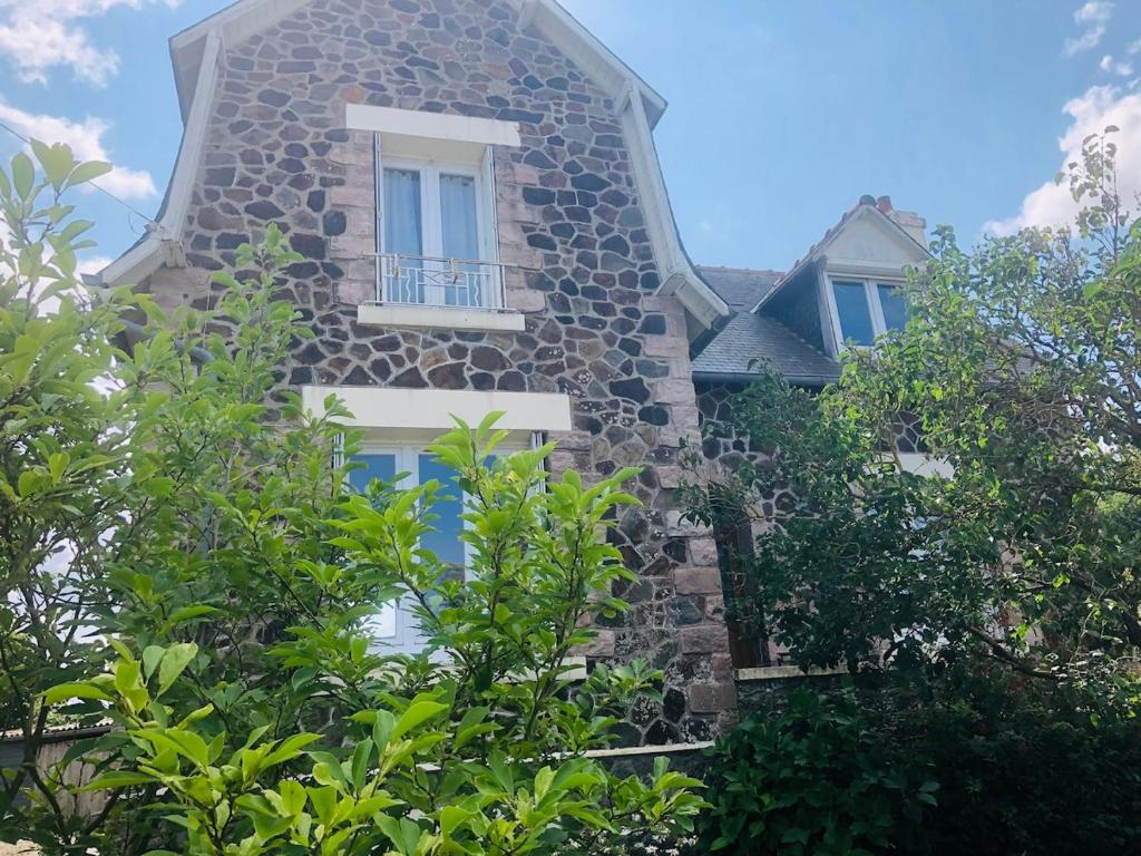 un bâtiment en pierre avec une fenêtre et des arbres dans l'établissement Villa Fenouil, à Binic