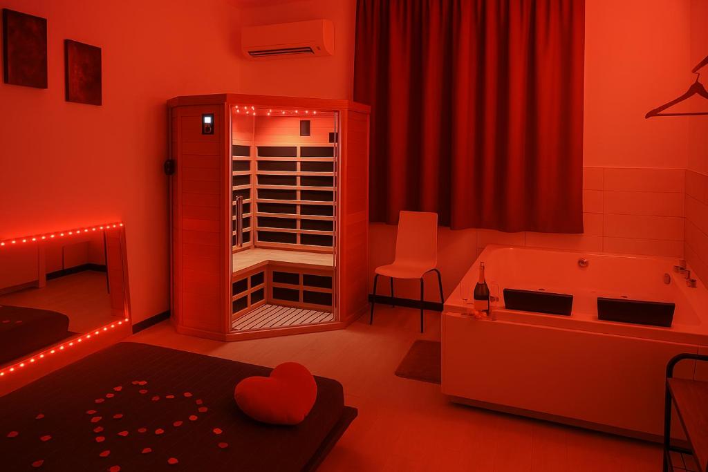 a red room with a bathroom with a tub and a room with at Lovers' Nest - Spa Apartment in Rome