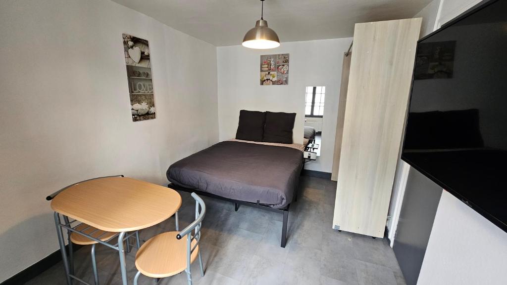 une petite pièce avec un lit et une table dans l'établissement Le Carrel, à Rouen