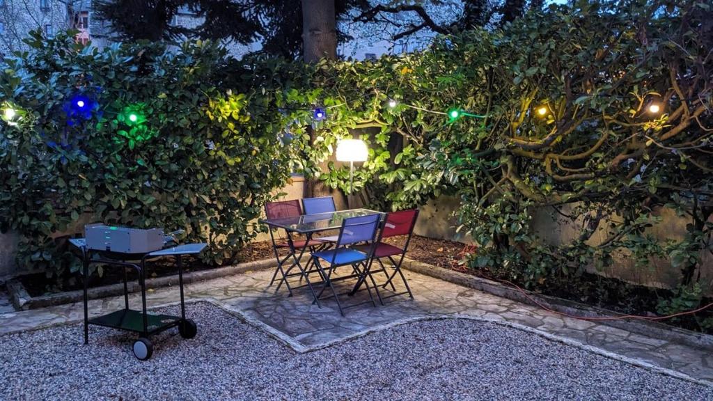 - une table et des chaises dans le jardin la nuit dans l'établissement Au Ptit Bonheur du Lot, centre-ville, calme, vue, jardin, à Espalion