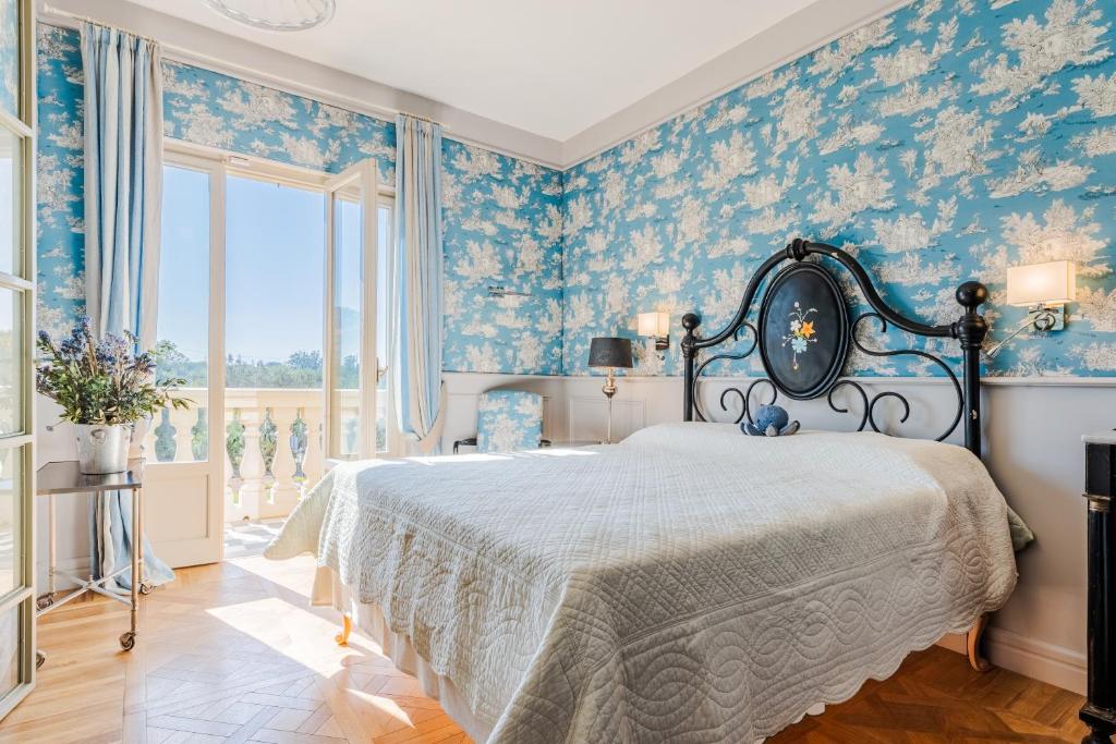 a bedroom with a bed with blue floral wallpaper at Tenuta Merlò in Castagneto Carducci