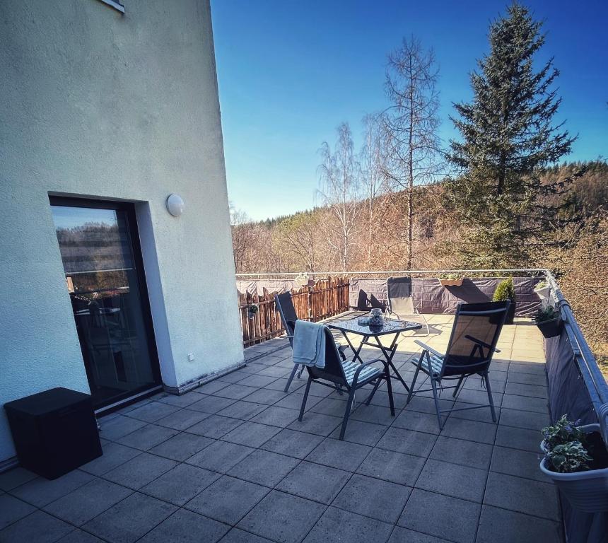 un patio con tavolo e sedie su un balcone di Quartier 3punkt0 alte Steigerbaude a Bad Gottleuba-Berggiesshübel