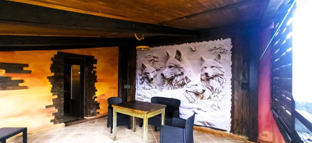 a mural of wolves on a wall with a table and chairs at El Guardaviñas, entre Montes y Viñedos in Ábalos
