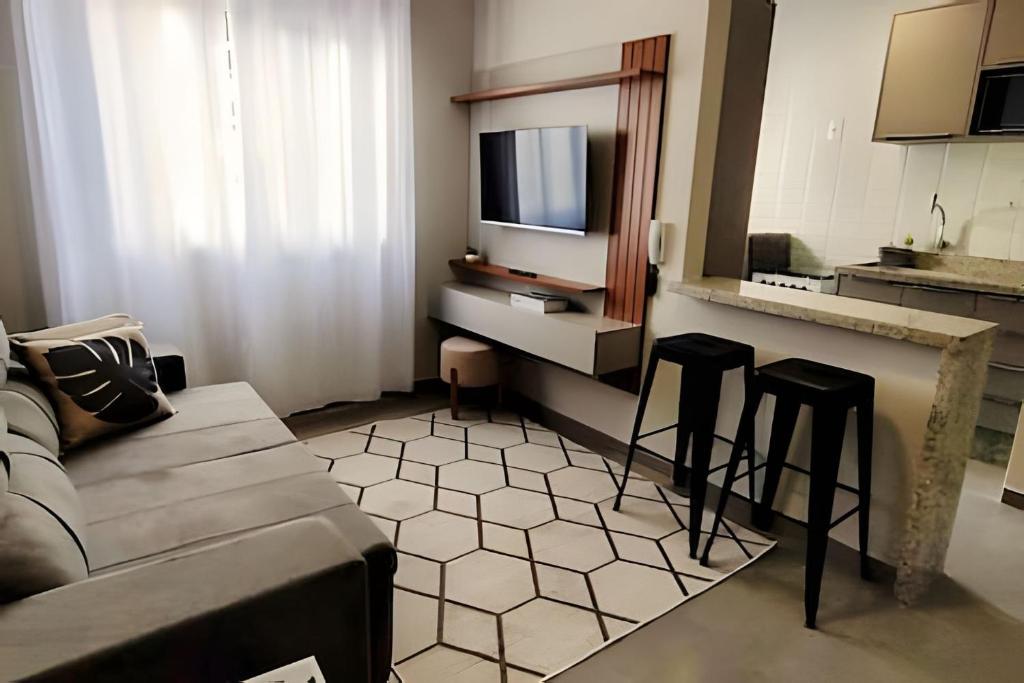 een woonkamer met een bank, een tafel en stoelen bij Apto 2 qtos com wi-fi e garagem in Londrina